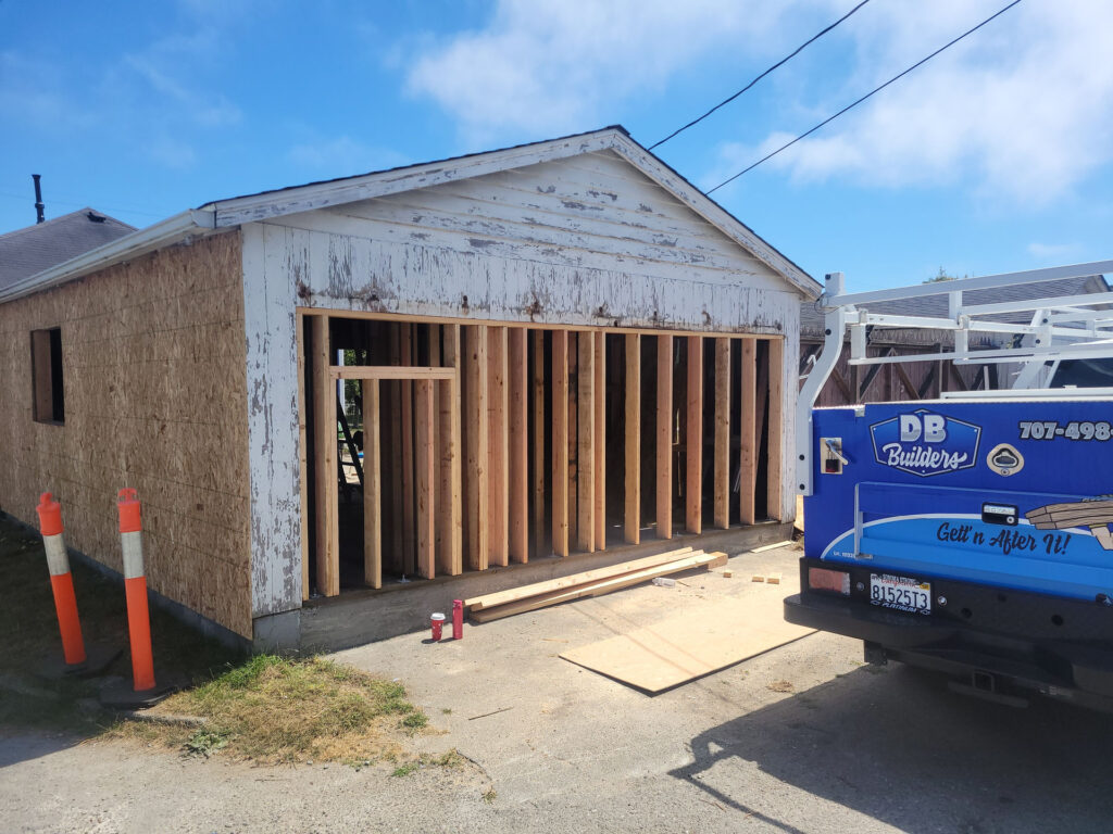 Douglas Biltzen's DB Builders renovating a garage in Humboldt County, CA, showing new wall framing with DB Builders truck nearby.