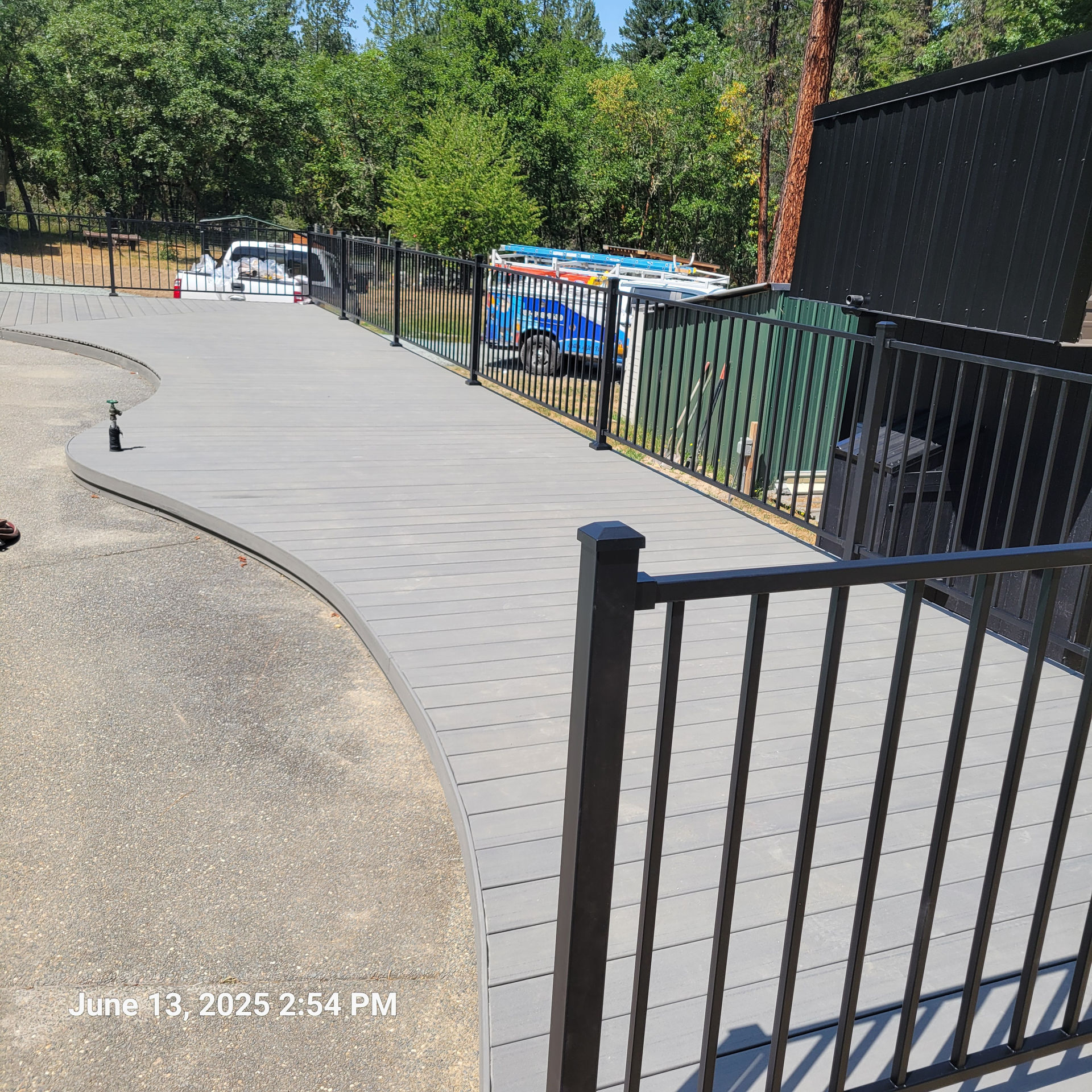 Douglas Biltzen's DB Builders installing curved composite deck with black metal railings in Humboldt County, CA
